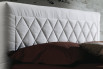 Detail of the upholstered bed with diamond quilting